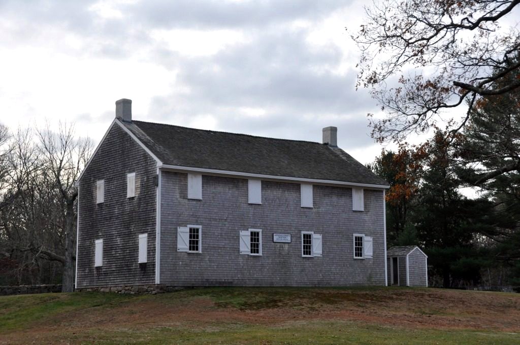 The Apponagansett Meeting House, a plain shingled 1790 Quaker meeting house on a grassy rise.